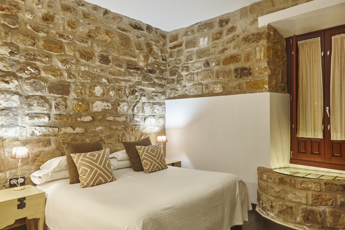 bedroom-with-stone-walls-comfortable-modern-hotel-room-interior-architecture